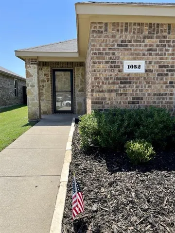 a front view of a building with a garden