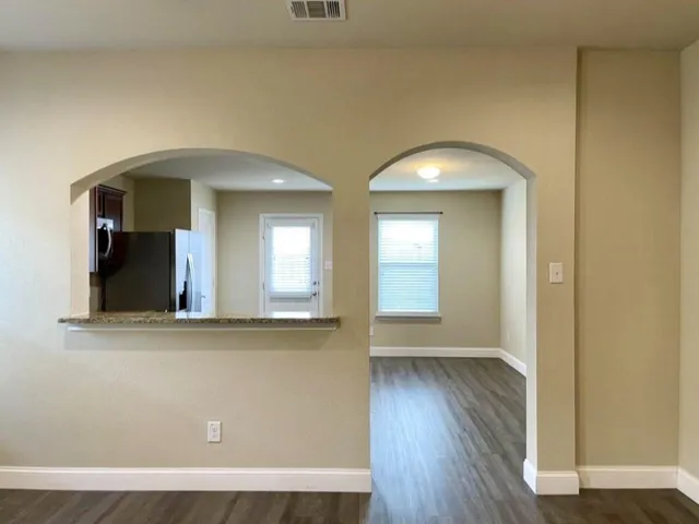 a view of a room that has a large window and wooden floor