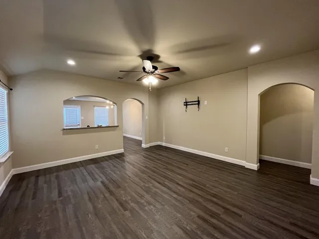 a view of an empty room with wooden floor