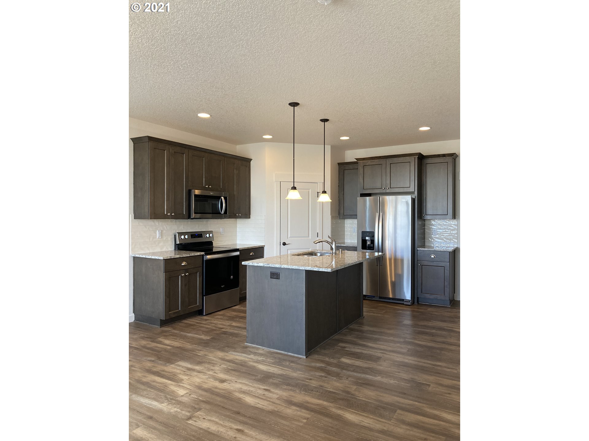 7113 South 11th Street Ridgefield, WA 98642 - Photo 2 of 7 a large kitchen with a sink and stainless steel appliances