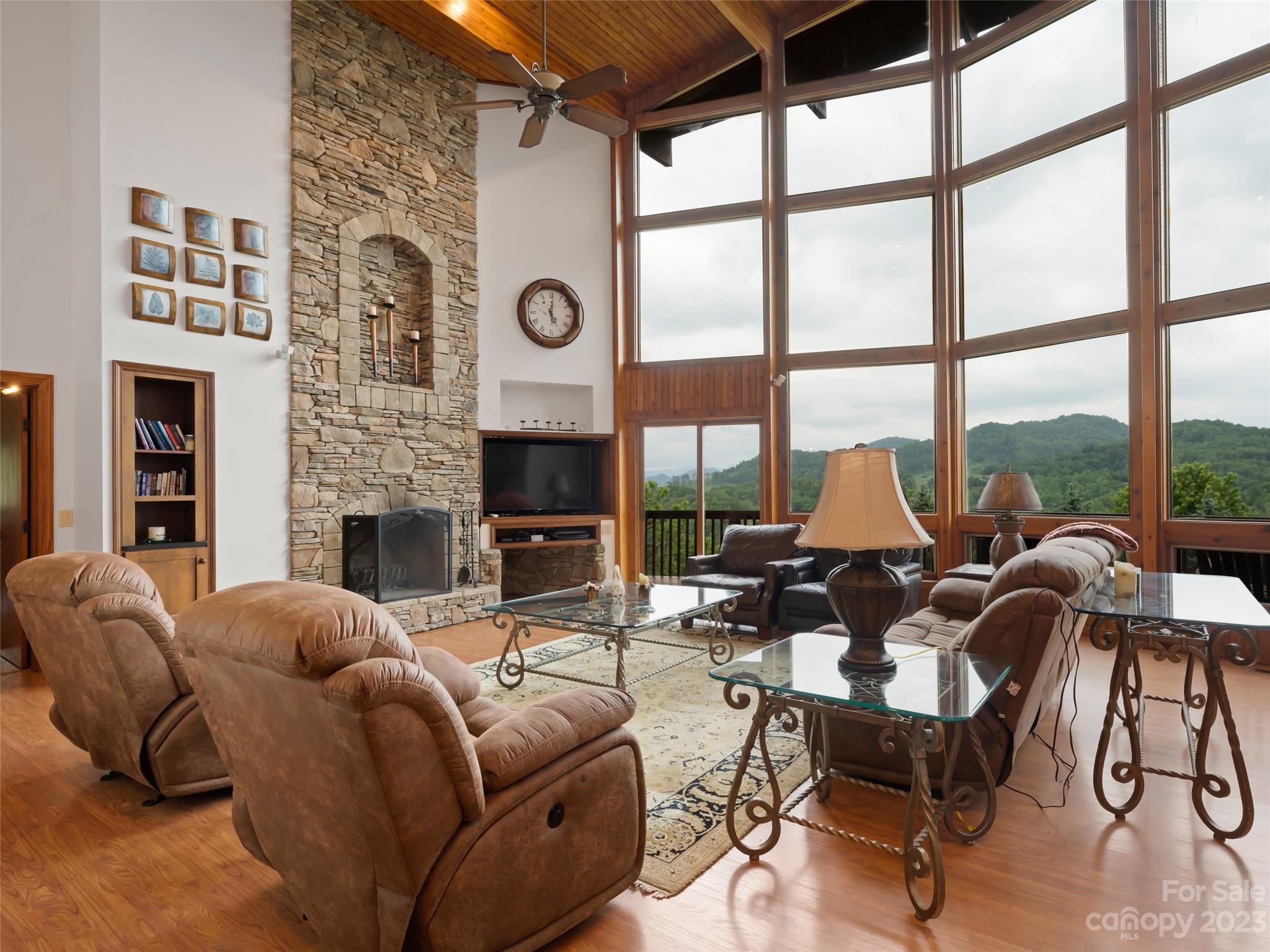 323 Lucky Lane Clyde, NC 28721 - Photo 14 of 48 a living room with furniture a fireplace and floor to ceiling windows