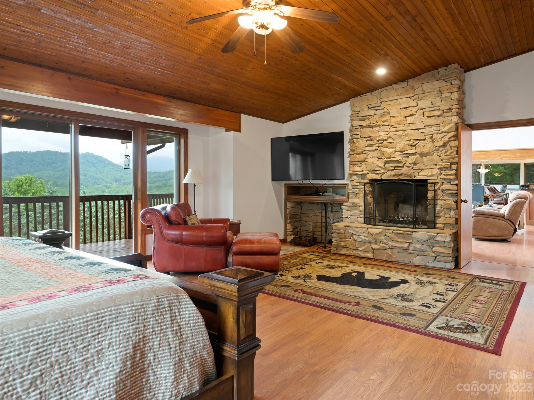 323 Lucky Lane Clyde, NC 28721 - Photo 29 of 48 a bedroom with furniture fireplace and a flat screen tv