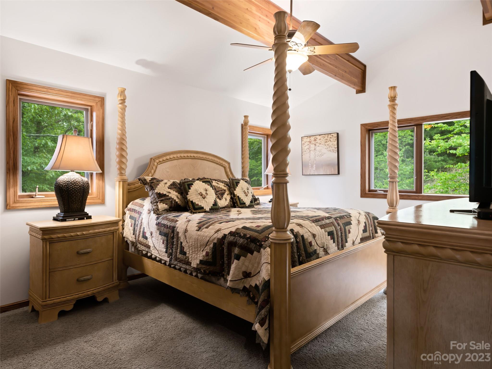 323 Lucky Lane Clyde, NC 28721 - Photo 32 of 48 a bedroom with a bed and a chandelier