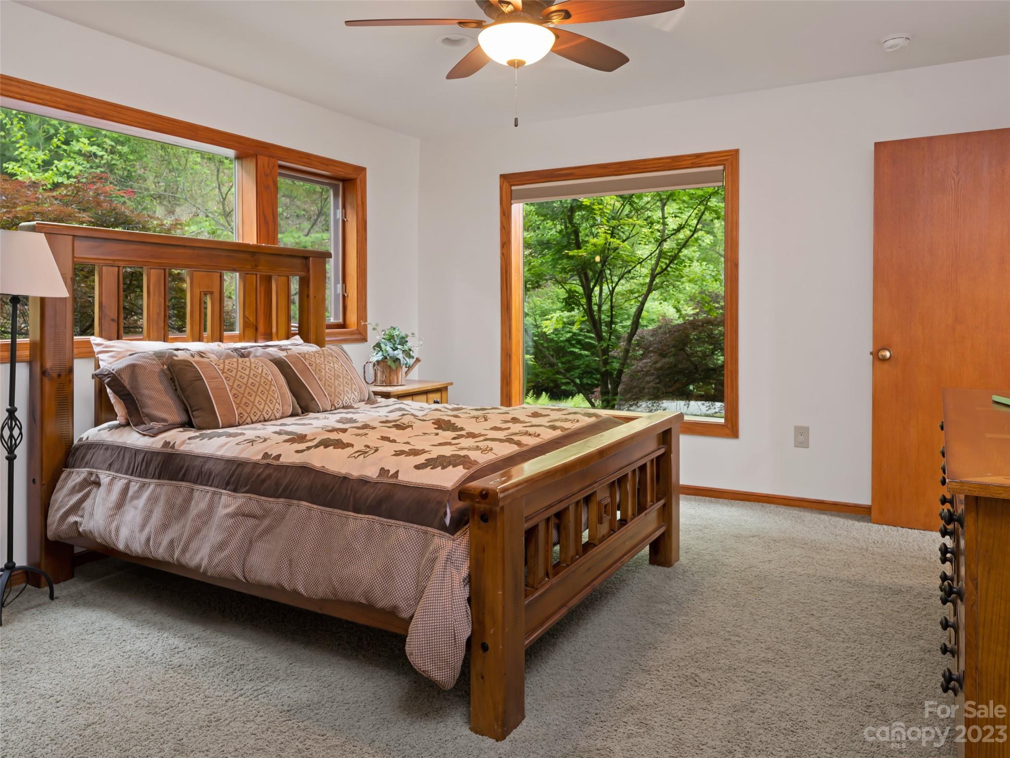 323 Lucky Lane Clyde, NC 28721 - Photo 36 of 48 a spacious bedroom with a bed lamp and window