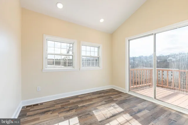 a view of a room with wooden floor and next to a window