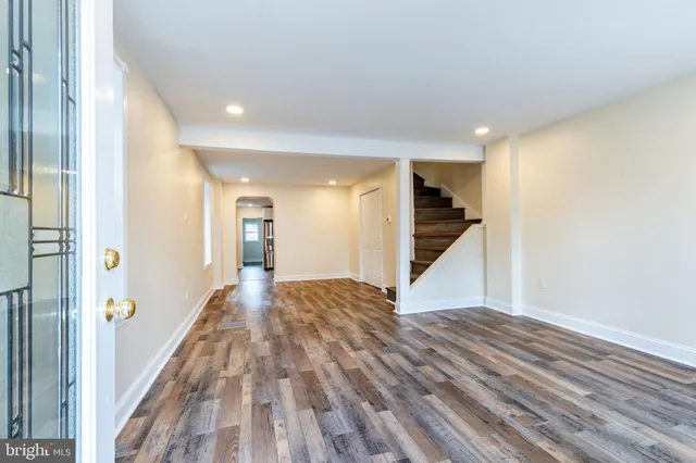 a view of a hallway with wooden floor and staircase