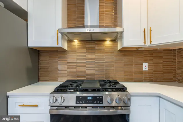 a stove top oven sitting inside of a kitchen