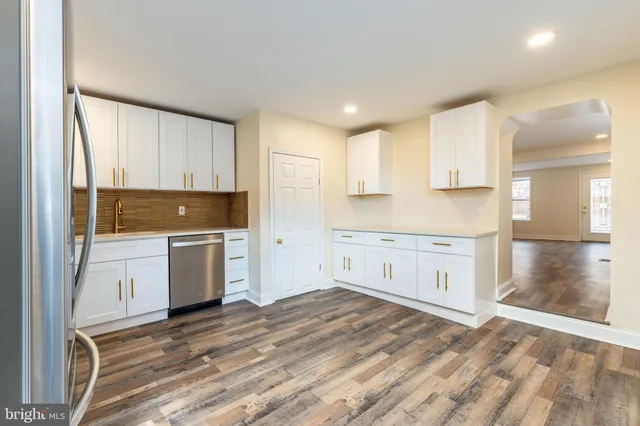 a kitchen with granite countertop white cabinets and white appliances