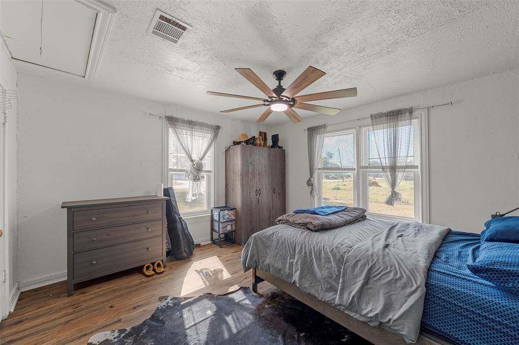 143 Crawford Mount Calm, TX 76673 - Photo 11 of 19 a bedroom with a bed and a chandelier