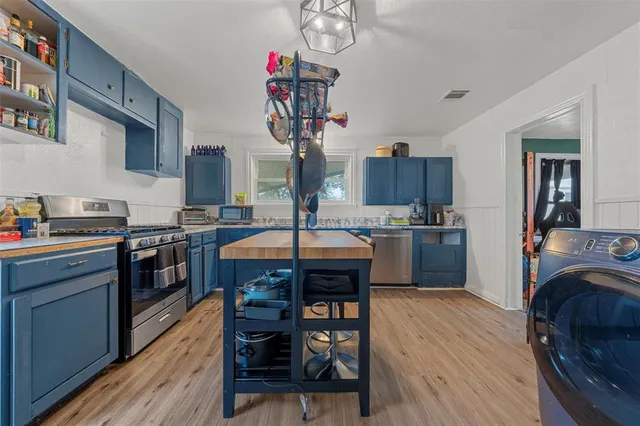 a kitchen with granite countertop wooden floors and wooden cabinets