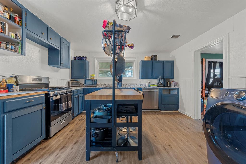 143 Crawford Mount Calm, TX 76673 - Photo 5 of 19 a kitchen with granite countertop wooden floors and wooden cabinets