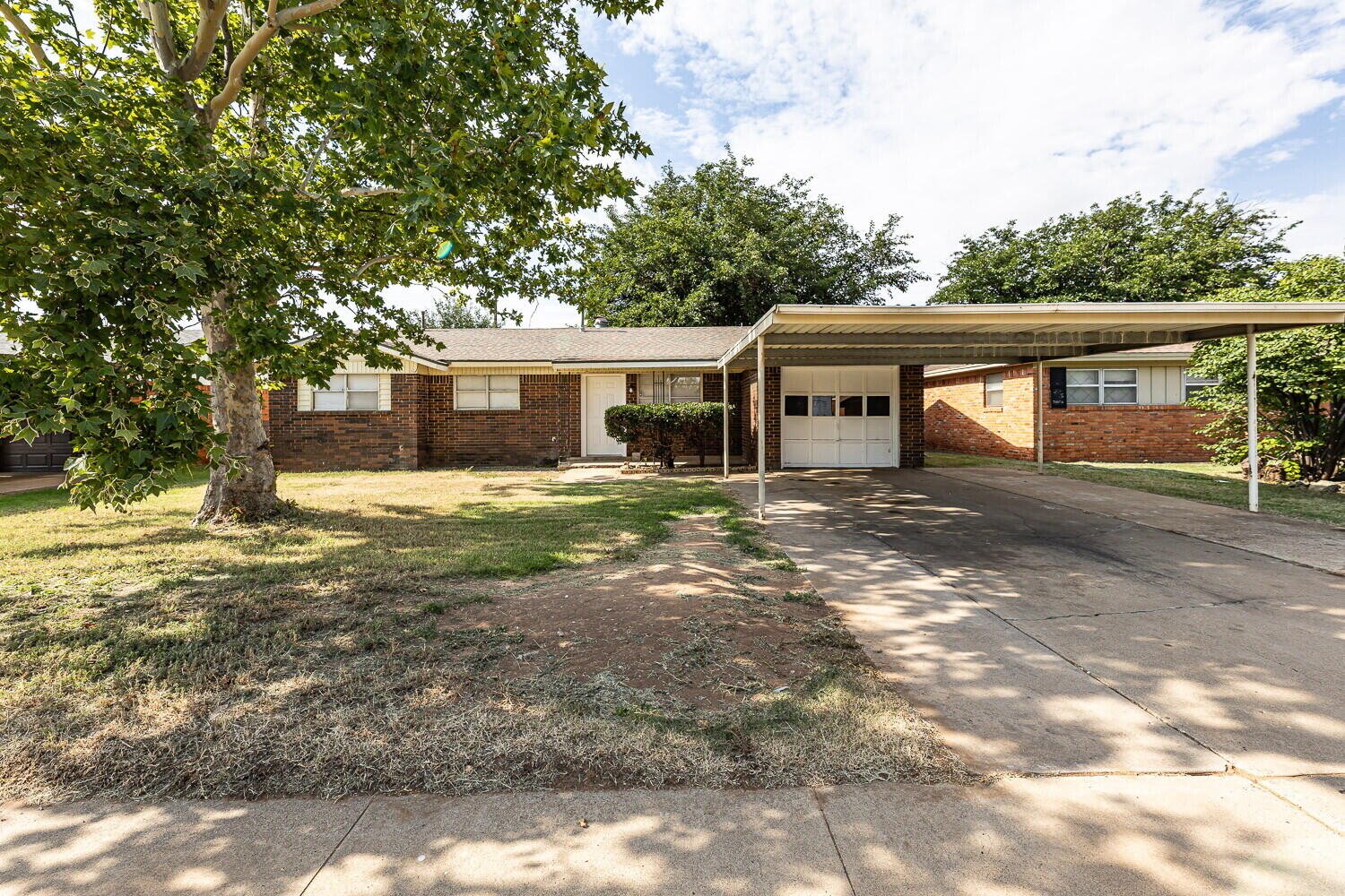 5517 16th Place Lubbock, TX 79416 - Photo 1 of 23 a front view of a house with a garden and trees