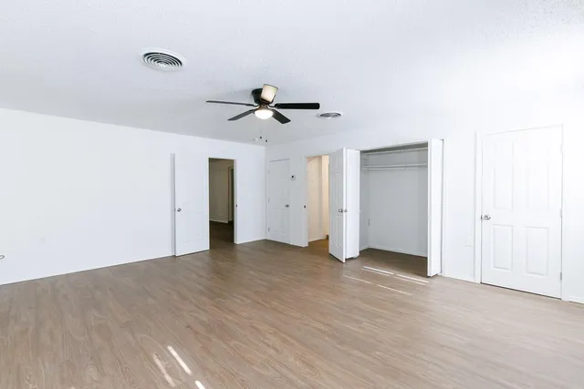 a view of an empty room with a ceiling fan
