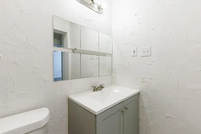 a bathroom with a sink toilet and a mirror