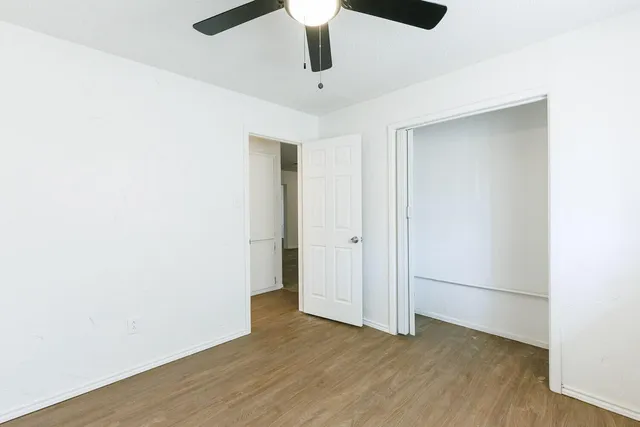 a view of an empty room with wooden floor