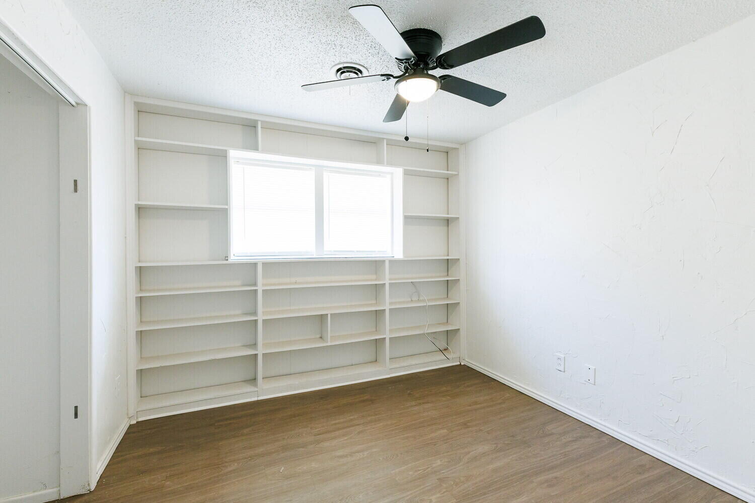 5517 16th Place Lubbock, TX 79416 - Photo 15 of 23 a view of an empty room with a window and a ceiling fan