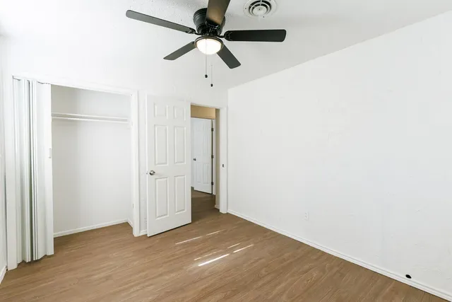 a view of empty room with wooden floor