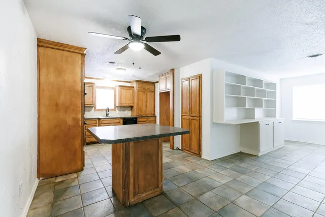 a kitchen with stainless steel appliances kitchen island granite countertop a refrigerator and a sink