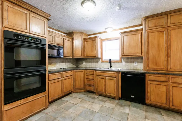a kitchen with stainless steel appliances granite countertop a stove microwave and cabinets
