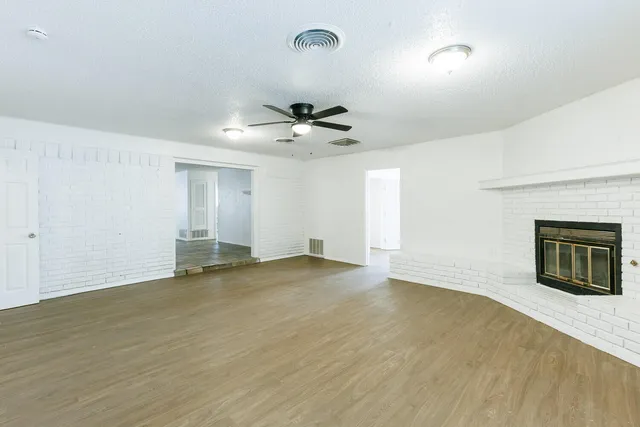 an empty room with fan and windows