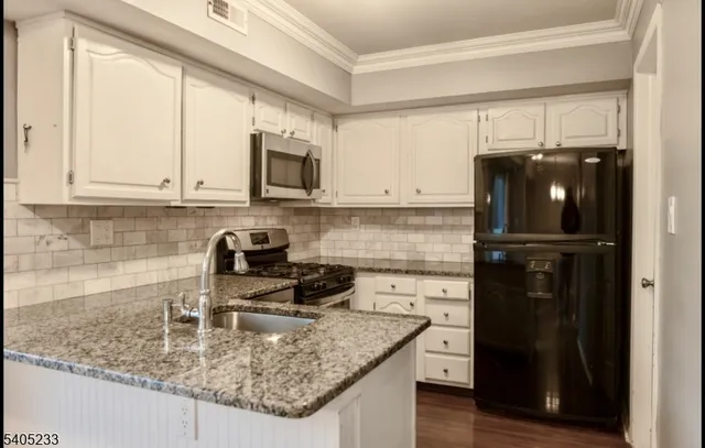a kitchen with a refrigerator stove and cabinets