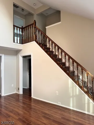 a view of staircase with lots of frames on wall and wooden floor