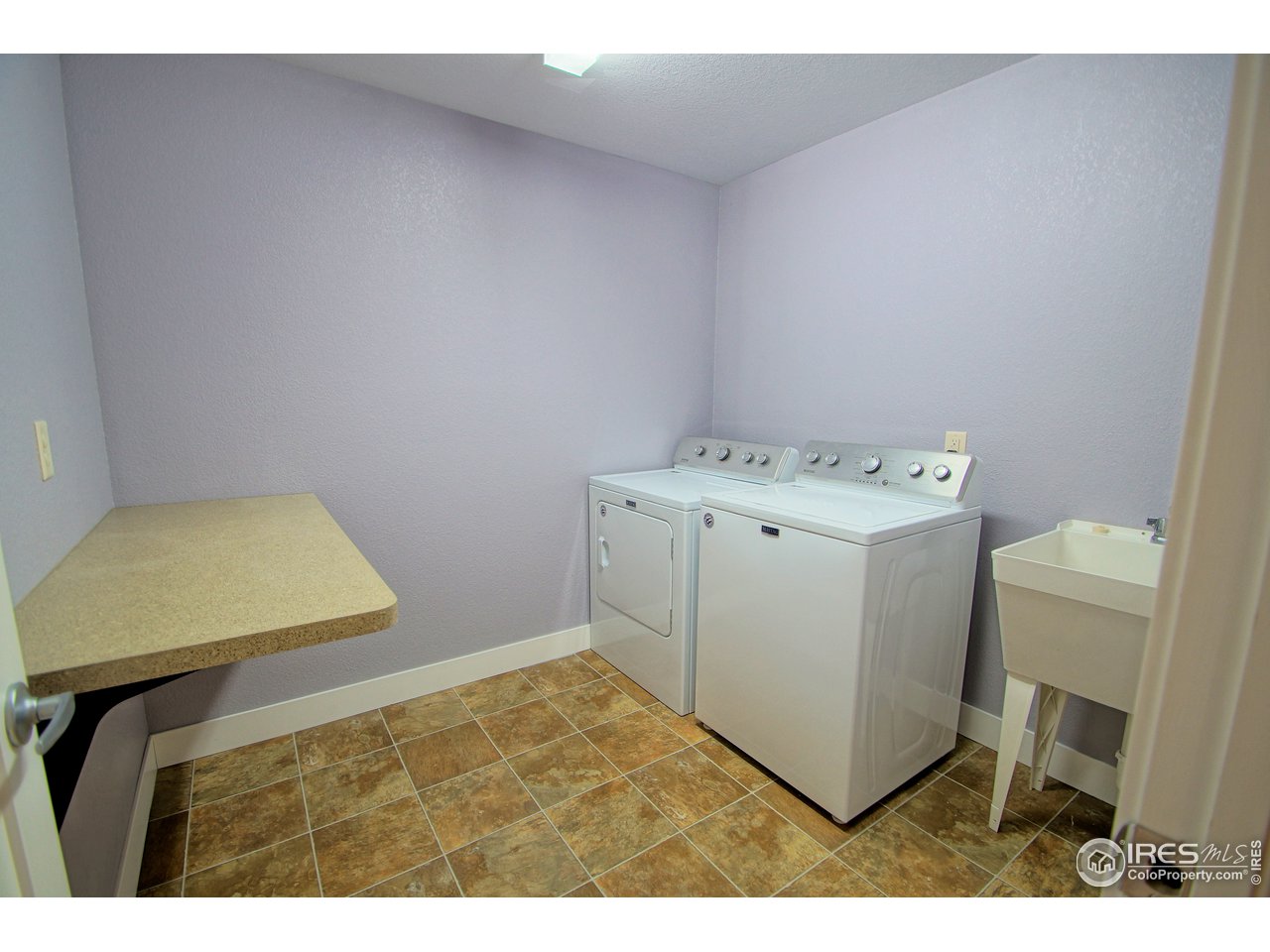 2008 Raven View Road Fort Collins, CO 80521 - Photo 23 of 36 Large Laundry Room in Basement level. Washer and Dryer included. They are less than a year old. Handy folding table and Utility Sink. Could be craft room also.