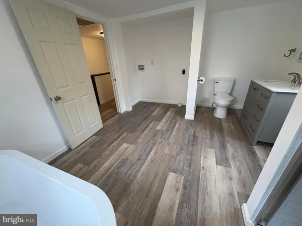 a view of a room with wooden floor and a bathroom