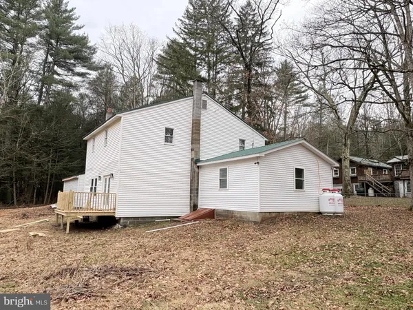 a view of a white house with a yard and wooden fence