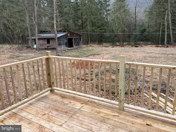a view of a wooden deck and a yard with swimming pool