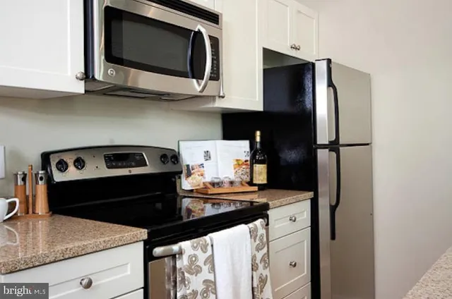 a kitchen with stainless steel appliances granite countertop a stove microwave and refrigerator