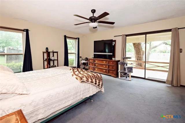 a bedroom with a bed and a large window