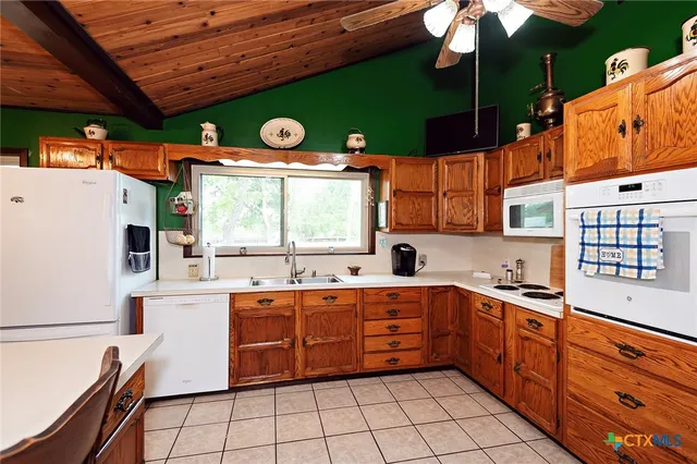 a kitchen with stainless steel appliances granite countertop a sink a stove and a refrigerator