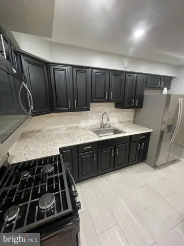 a kitchen with a stove a sink and a refrigerator