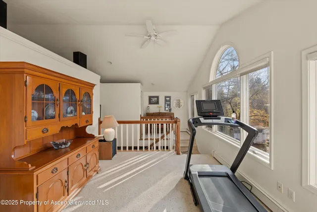 a living room with furniture a flat screen tv and a large window
