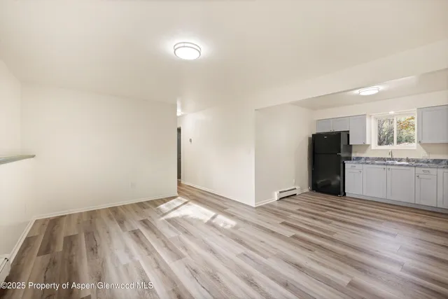 a view of a kitchen with wooden floor and stainless steel appliances