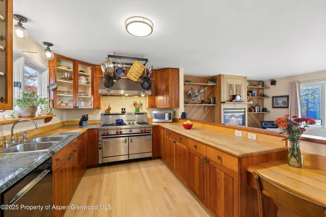 a large kitchen with stainless steel appliances lots of counter space and a sink