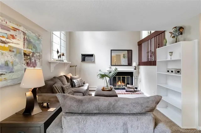 a living room with fireplace furniture and a large window