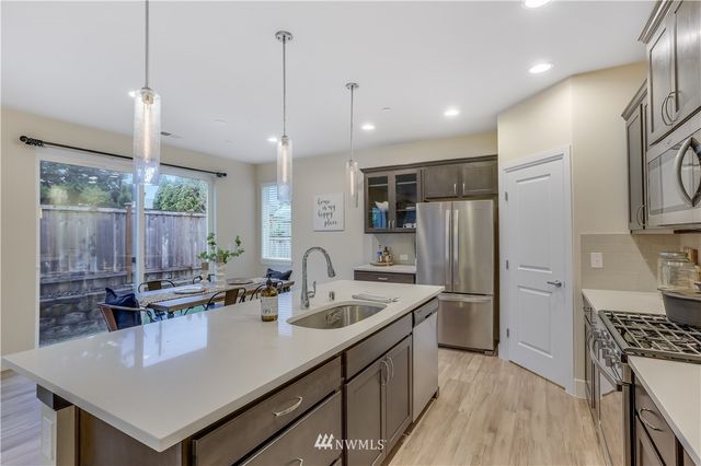 a kitchen with stainless steel appliances granite countertop a sink a stove and a refrigerator