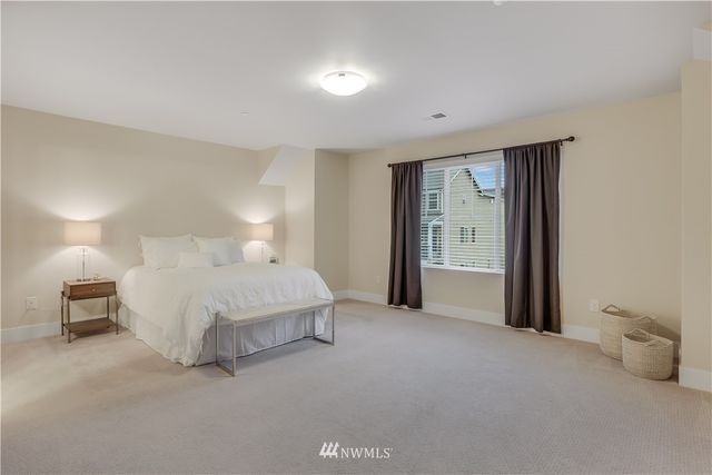 a spacious bedroom with a bed and a lamp