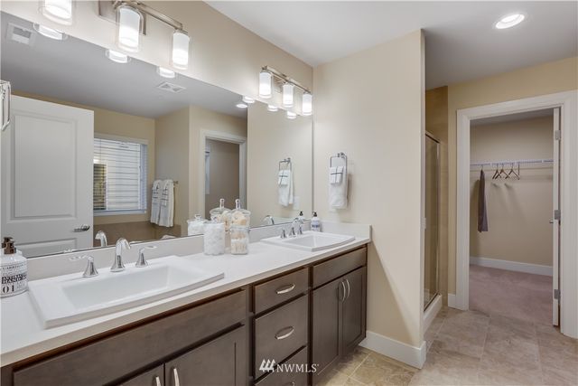 a bathroom with double vanity sinks and a mirror