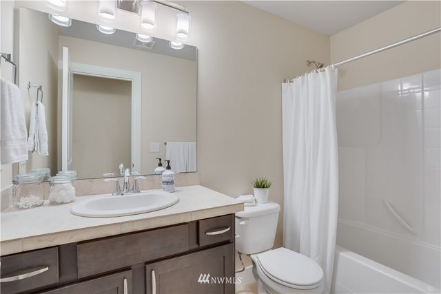 a bathroom with a sink toilet vanity and shower