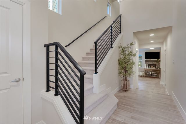 a view of a hallway to a livingroom with furniture and stairs