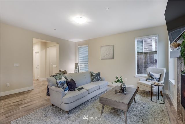 a living room with furniture a flat screen tv and a window