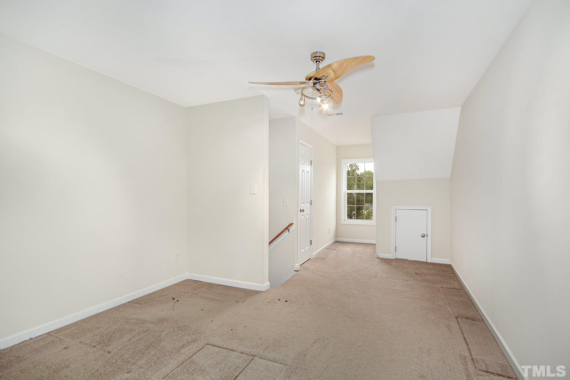 5852 Wynmore Road Raleigh, NC 27610 - Photo 21 of 25 an empty room with chandelier fan and windows