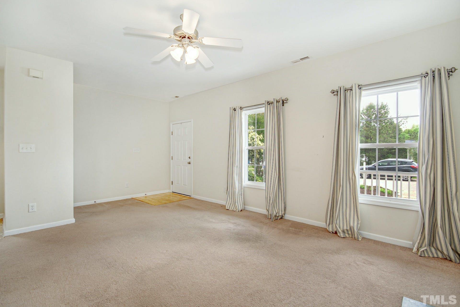 5852 Wynmore Road Raleigh, NC 27610 - Photo 6 of 25 an empty room with windows and fan
