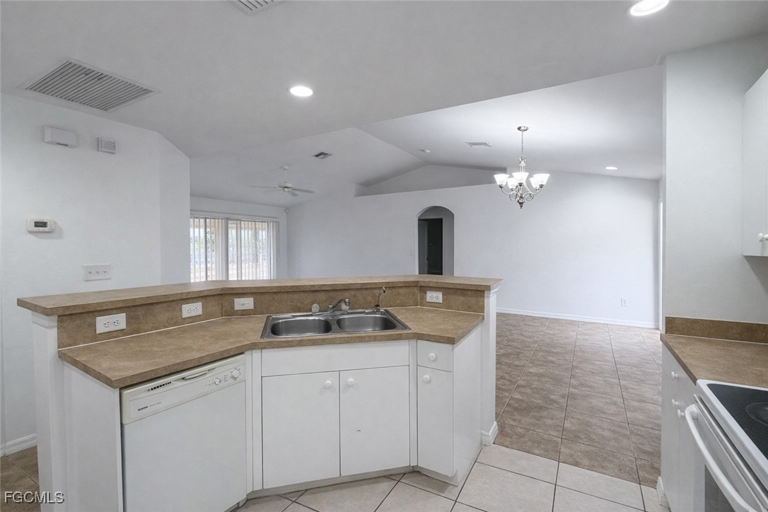 3215 13th Street Southwest Lehigh Acres, FL 33976 - Photo 5 of 12 a kitchen with a sink and chandelier