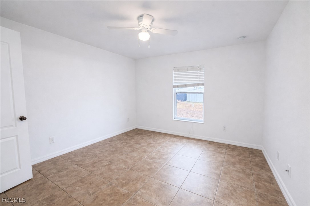 3215 13th Street Southwest Lehigh Acres, FL 33976 - Photo 7 of 12 an empty room with a window and a ceiling fan