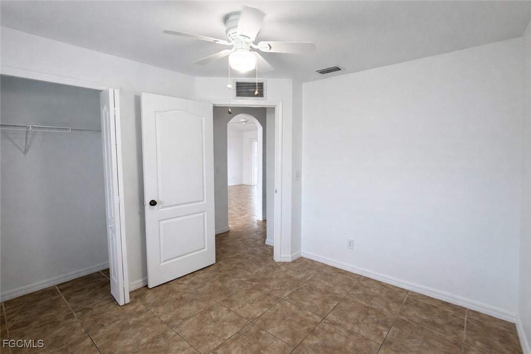 3215 13th Street Southwest Lehigh Acres, FL 33976 - Photo 9 of 12 an empty room with a ceiling fan and a window