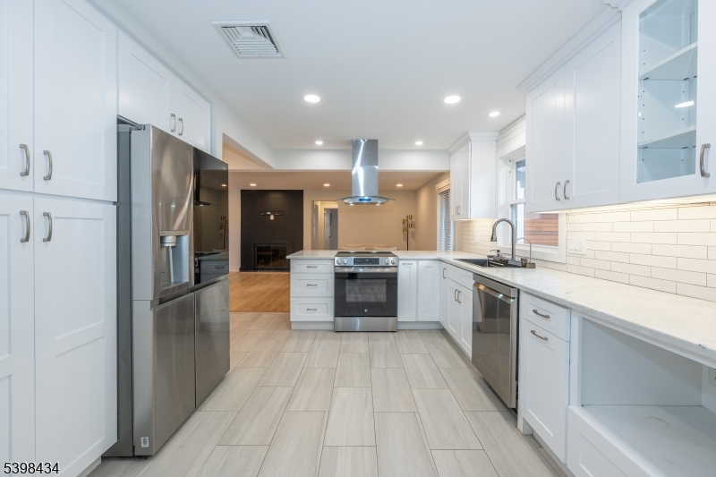 7 Oak Tree Lane Little Falls, NJ 07424 - Photo 17 of 46 a large kitchen with a large counter top stainless steel appliances and cabinets